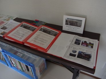 集会所の入口を入ったところのテーブル。柳沢さん製作し持参してくださった、仮設住宅のトリセツ！ファイル。